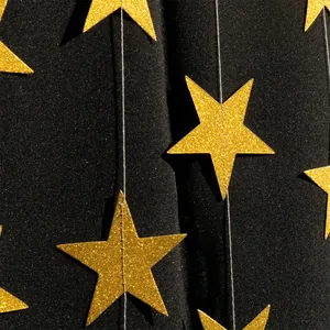 Close-up of golden glitter star garland decorations for festive and wedding party layouts