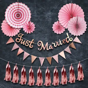 Pink and rose gold party set with paper fans, Just Married banner, and foil tassels