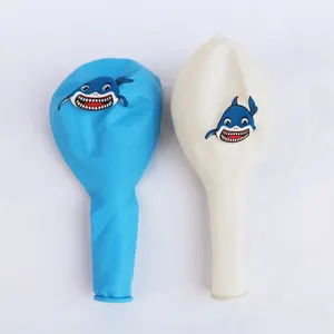 Detail view of blue and white latex balloons with cartoon shark prints for birthday decor