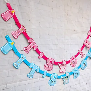 Dettaglio degli striscioni It's a Girl e It's a Boy per baby shower su muro bianco