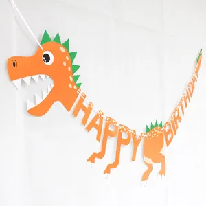 Close-up of orange dinosaur Happy Birthday banner with green scales for party decor