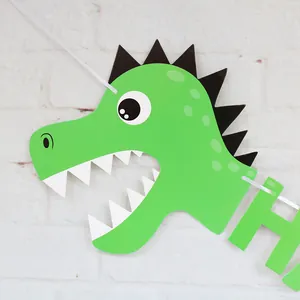 Detail of green dinosaur party banner with a cartoon head and a letter H cutout