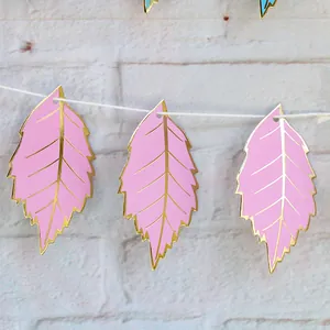 Partybanner mit rosa Blättern und goldenem Rand an einer weißen Wanddekoration