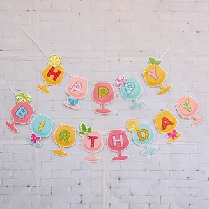 Dettaglio dello striscione colorato Happy Birthday a sirena su sfondo muro di mattoni bianchi