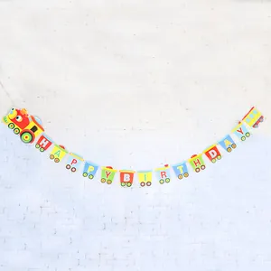 Colorful cartoon train Happy Birthday banner hanging on a white brick wall
