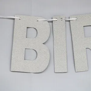Macro view of silver glitter Happy Birthday banner with metallic texture and ribbon