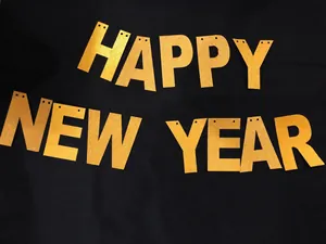 Κοντινό πλάνο με χρυσά γράμματα Happy New Year με γκλίτερ σε μαύρο φόντο