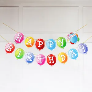 Kleurrijke verjaardagsslinger in ballonvorm op witte muur met Enjoy Your Day kaartje