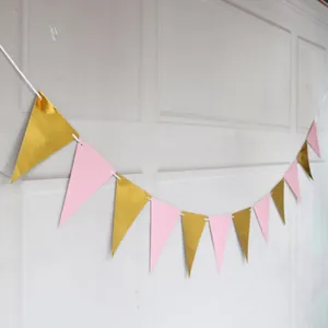 Pink and metallic gold triangle bunting banner for party decoration on a white wall
