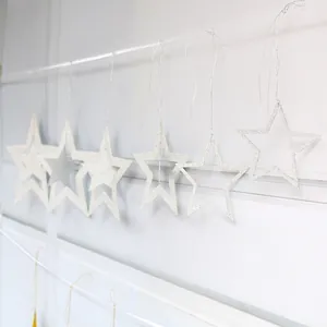 Close-up of silver glitter hollow star ornaments with strings for festive party decoration
