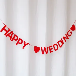 Red felt HAPPY WEDDING banner with heart shapes for festive wedding party wall decor