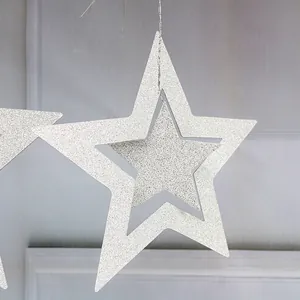 Close-up of glittery silver hollow star ornament with hanging string for party decor