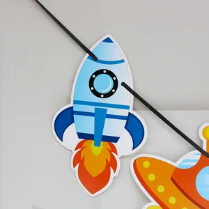 Detail of cartoon rocket and UFO paper banner decorations for outer space party