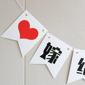 Detail of white swallowtail wedding banners with red hearts and black Chinese calligraphy