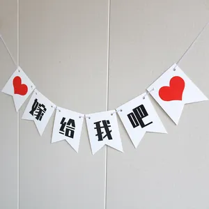Close-up of Chinese wedding bunting with the words Will You Marry Me and red hearts