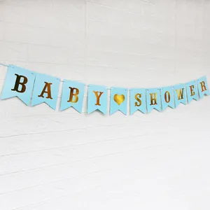 Baby Shower Girlande in Blau und Gold für Partydekorationen auf weißem Ziegelhintergrund
