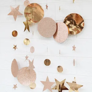 Close-up of champagne and rose gold star and circle garland with glitter finish