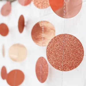 Macro shot of rose gold glitter and mirror finish circle paper garland for party decoration