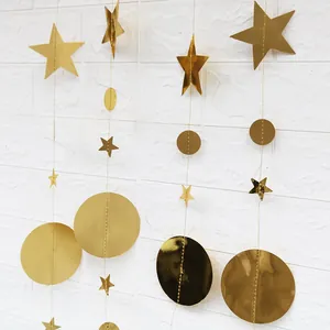 Golden star and circle garland hanging on a white brick wall for festive decoration