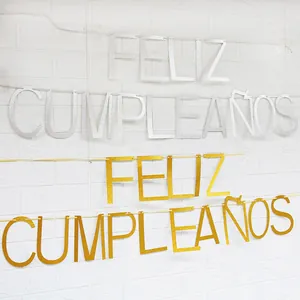 Λαμπερές χρυσές και ασημένιες σημαίες Feliz Cumpleaños σε λευκό τοίχο με τούβλα