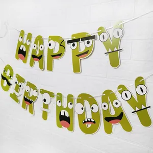 Λεπτομέρεια banner Happy Birthday με τέρατα και πράσινα γράμματα σε λευκό τοίχο