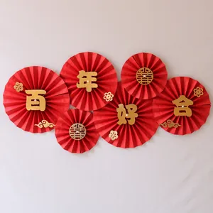 Detailed view of Chinese wedding paper fans with gold characters and pearl accents