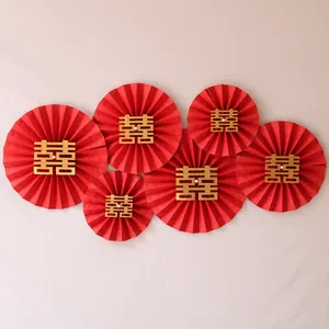 Close-up of red wedding paper fans with gold Double Happiness symbols for wall decor