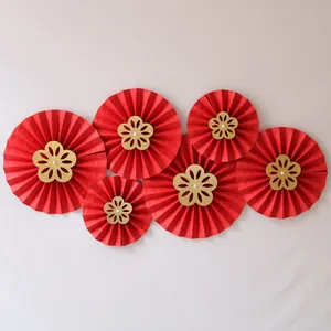 Detail of red wedding paper fans with gold glitter centers and pearl embellishments