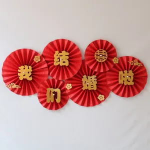 Detail of red wedding paper fans with gold glitter Chinese calligraphy and cloud accents