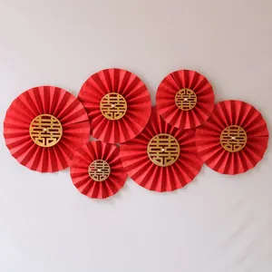 Detail of red wedding paper fans with golden Xi character and pearl center decor