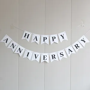 Detalle de los carteles blancos de cola de milano con letras negras de Happy Anniversary