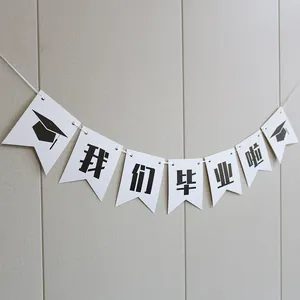 Detail of white swallowtail graduation bunting with black doctoral cap and Chinese text