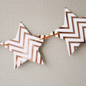 Detail of rose gold and white star-shaped banners with chevron pattern on gold ribbon