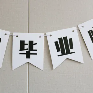 Detail of white cardstock GRAD party banner with black Chinese graduation lettering