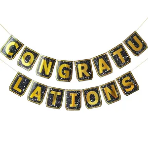 Close-up of CONGRATULATIONS banner with gold foil letters and black starry background