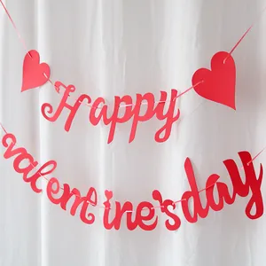 Close-up of red glittery Happy Valentine's Day heart banner on white fabric backdrop