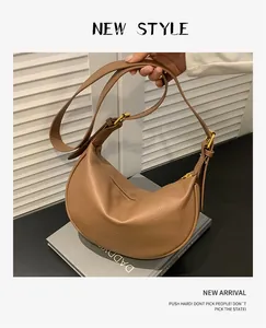 Detail view of brown lychee texture crescent bag with golden zipper and adjustable strap