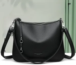 Close-up of black lychee grain texture leather bag with silver metal zipper details