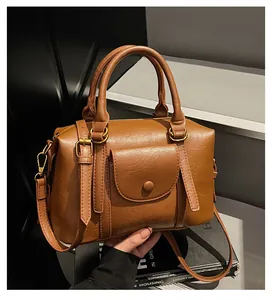 Detail of caramel brown Boston bag showing premium leather texture and retro hardware