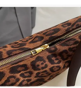 Detail of high-quality gold metal zipper on leopard print faux suede crossbody bag