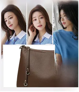 Detail of dark brown lychee leather texture and silver zipper on luxury shoulder bag