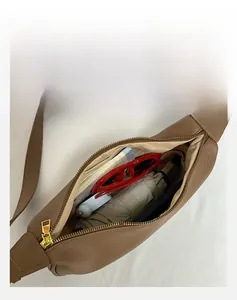 Detailed interior of brown pebbled leather crescent bag showing 23cm umbrella capacity