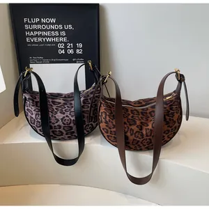 Detailed view of two leopard print crescent bags in brown and grey-purple faux suede