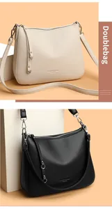 Close-up of lychee grain leather bags in beige and black with silver zippers and logos