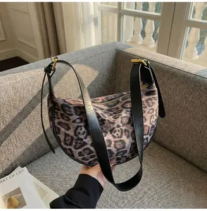 Detailed close-up of leopard print hobo bag with gold buckle and black leather strap