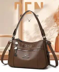 Detail shot of dark brown litchi pattern leather bag with metallic zipper and gold charms