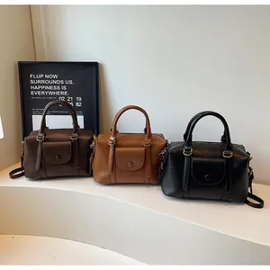 Detailed display of vintage Boston handbags in dark brown, khaki, and black leather
