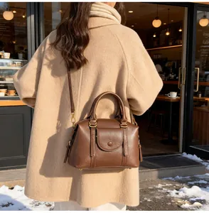 Detail of a brown leather Boston bag with vintage gold zippers and outdoor styling