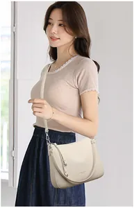 Detail of cream lychee texture shoulder bag with adjustable strap on a female model