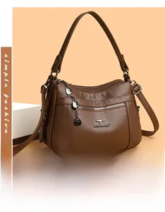 Detail of brown litchi leather bag with metallic kangaroo logo and adjustable strap